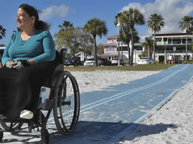 Woman in wheelchair on Mob-Mat on the beach