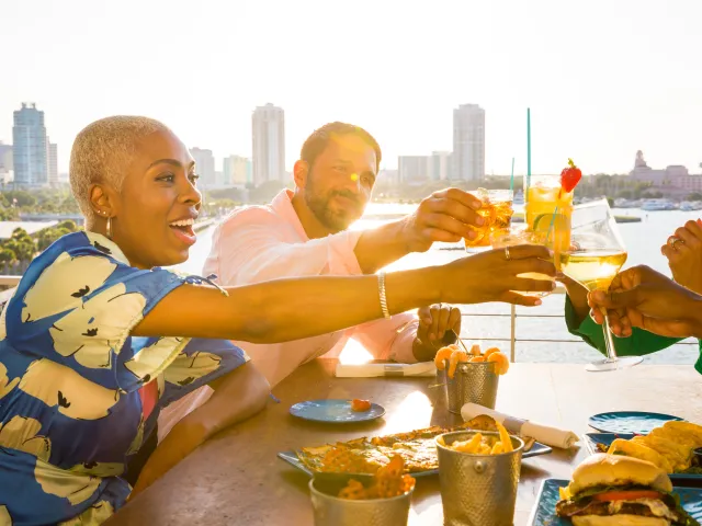 a group of friends toasting with drinks at Pier Teaki at the St. Pete Pier