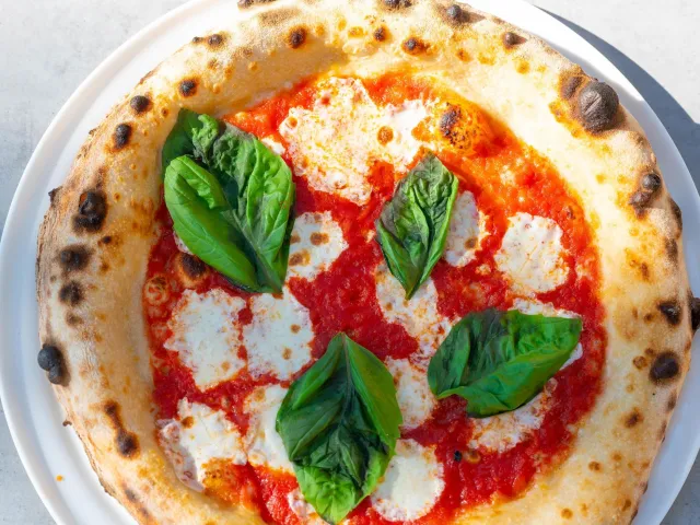 Small pizza with tomato sauce, cheese and fresh basil