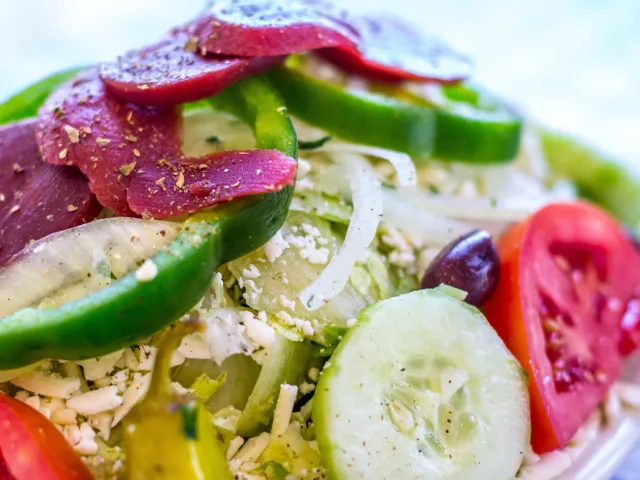 colorful greek salad with beets, green peppers, tomatoes, onions, feta cheese