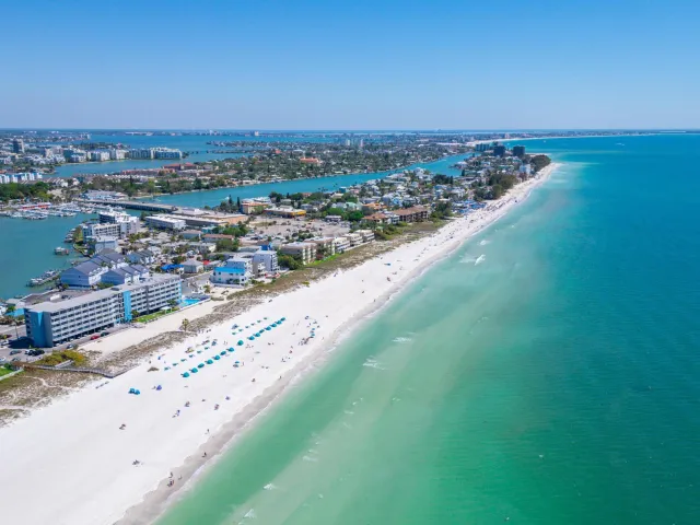 An aerial view of the ocean, beach and buildings along the shore