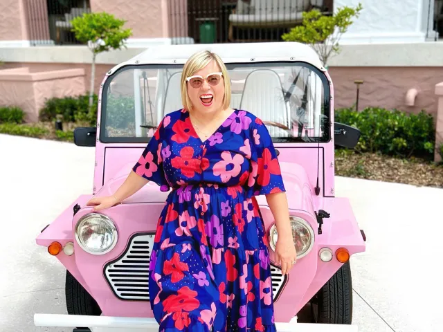 woman standing in front of pink car