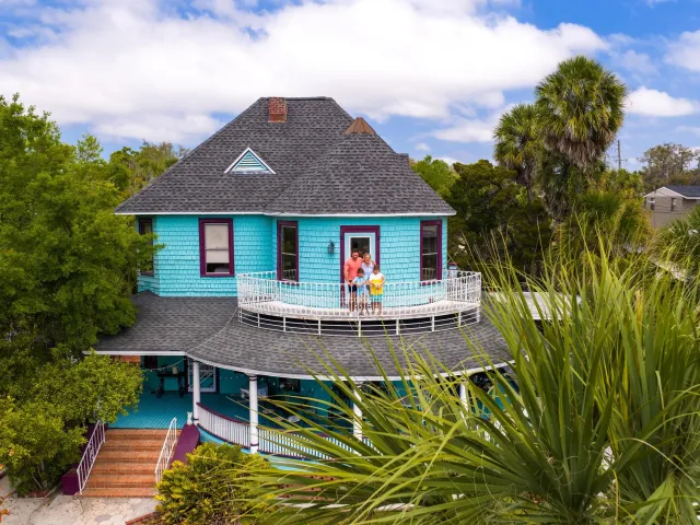 a family standing on the balcony of the Victorian-style 1910 Inn in Tarpon Springs