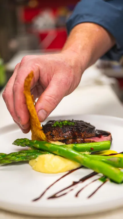 a chef puts the finishing touches on a dish at The Black Pearl in Dunedin