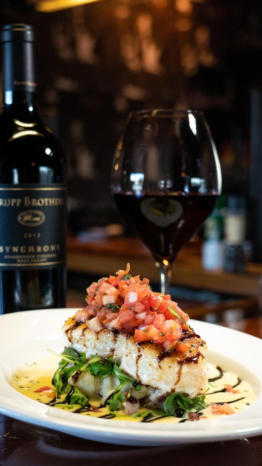 A plated dish and red wine pairing at 1200 Chophouse on St. Pete Beach