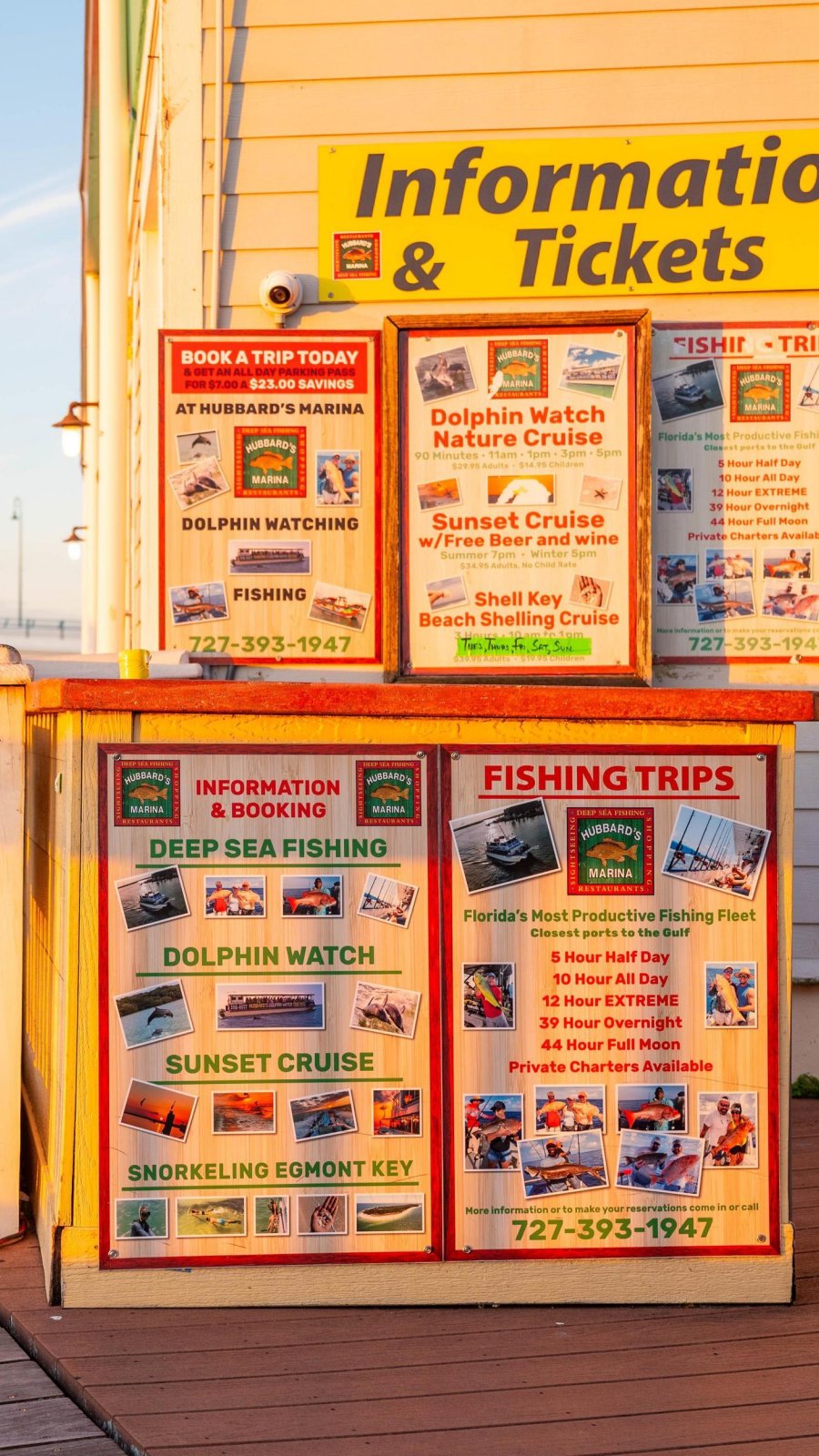 signs on a dock featuring boat and fishing charter information