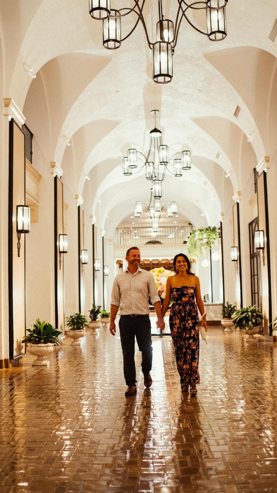 man and woman couple walking holding hands through vinoy hotel lobby