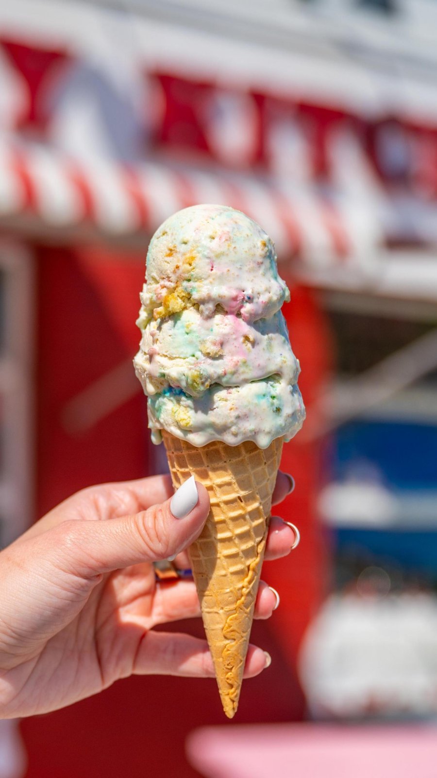 hand holding ice cream cone with three scoops