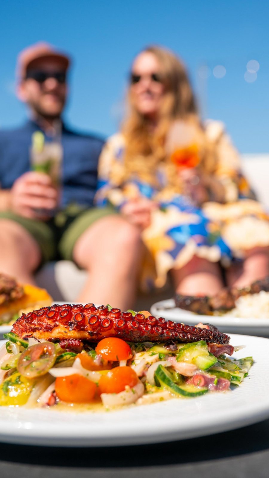 decorative plate of octopus with couple sitting in background