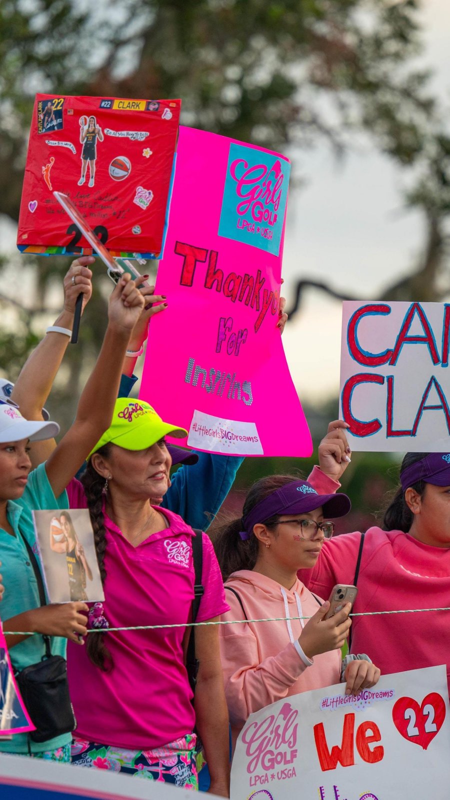 fans hold signs for their favorite players at The Annika golf tournament
