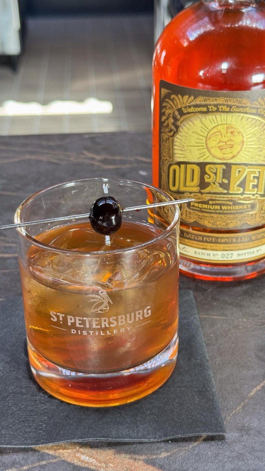 cherry chocolate old fashioned with a bottle of Old St. Pete Vodka next to it at St. Pete Distillery