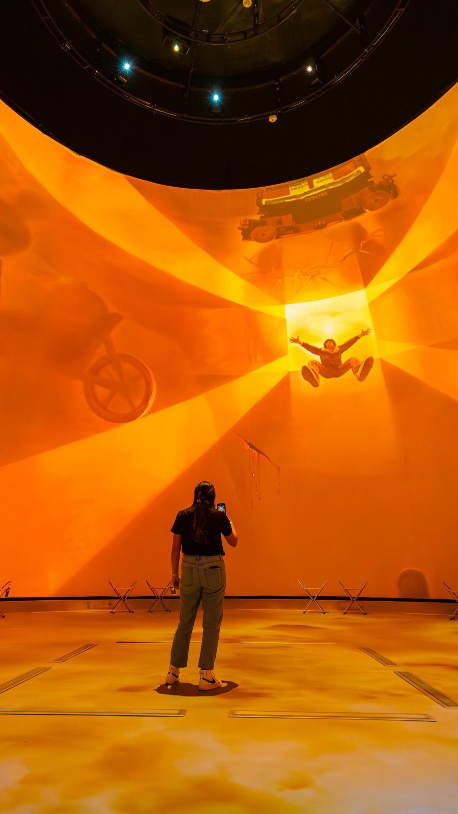 a young woman stands in the middle of a multi-media experience in the Dali Dome at the Salvador Dali Experience
