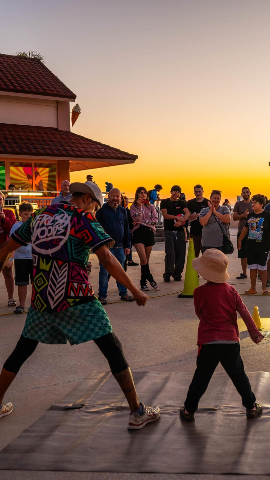 a busker includes a young visitor in his act at Sunsets at Pier 60 in Clearwater Beach