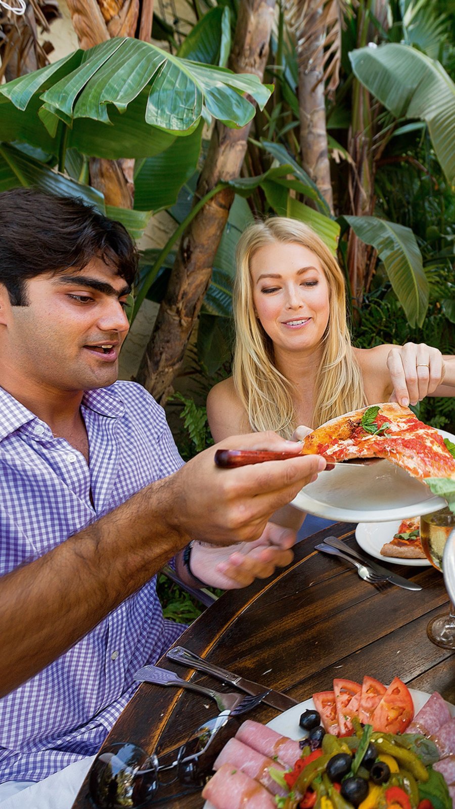 a couple enjoying pizza and appetizers while dining outside at Cristino's Coal Oven Pizza in Clearwater