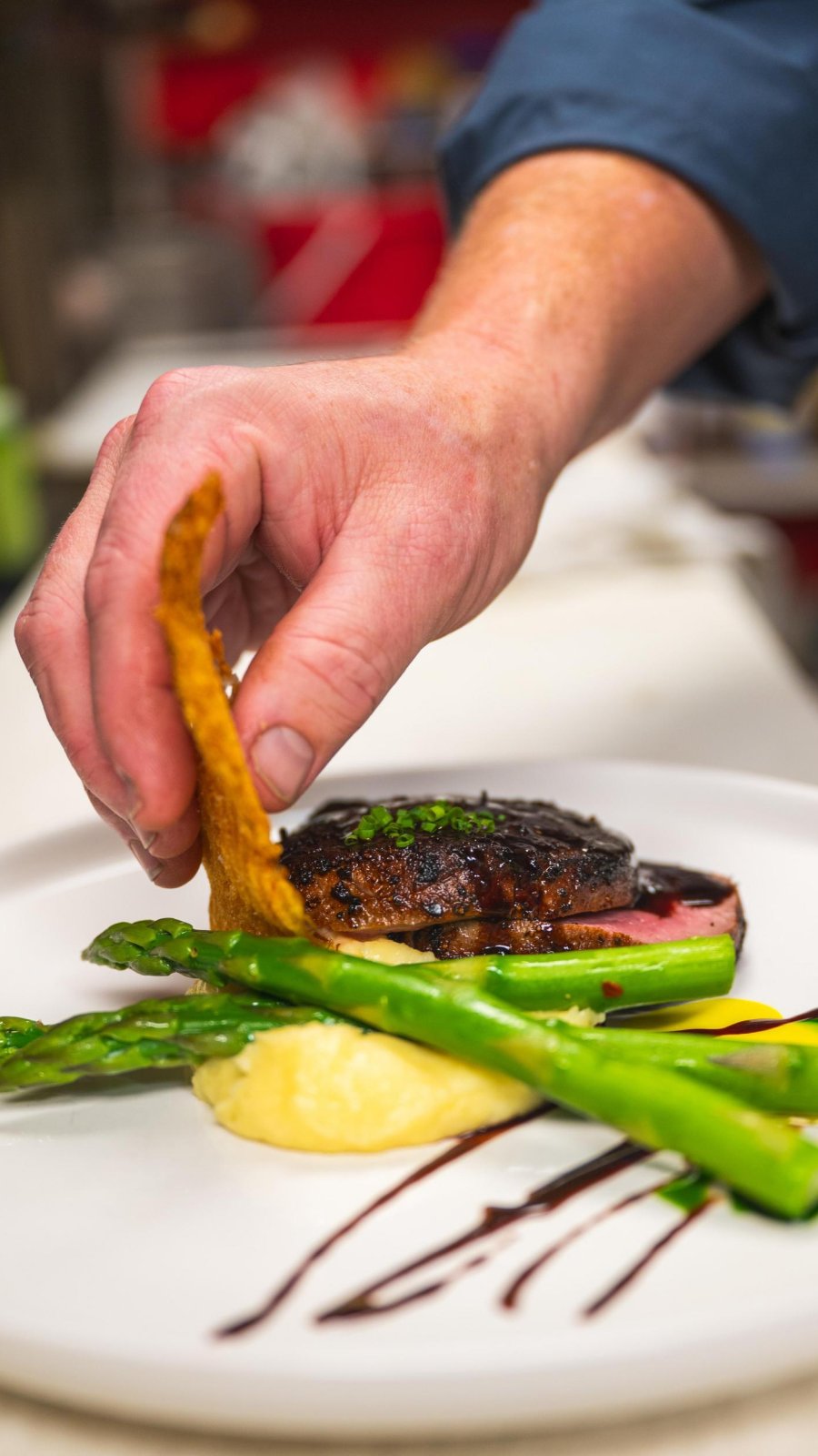 a chef puts the finishing touches on a dish at The Black Pearl in Dunedin